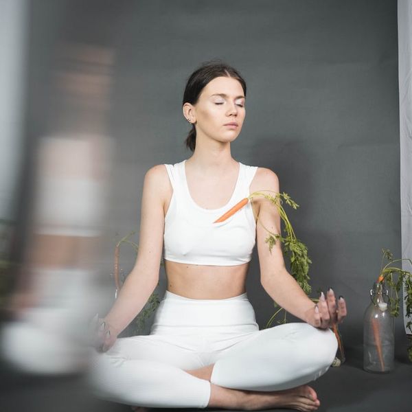 Peaceful woman meditating in a bright minimalist studio environment